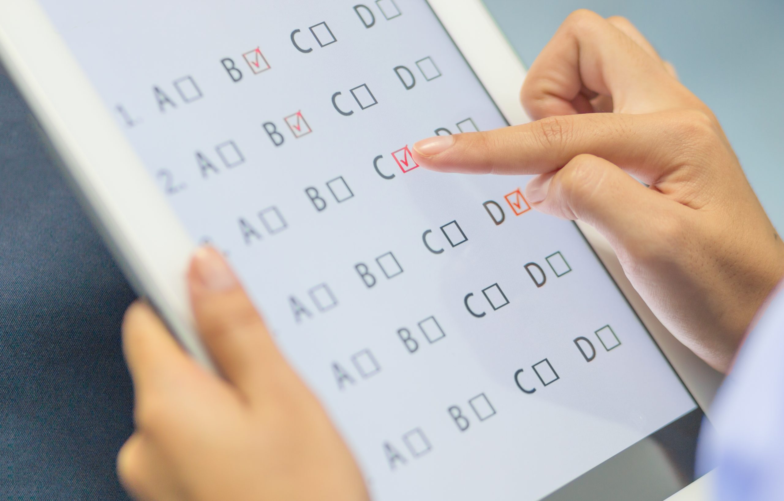 Student holding a tablet ticking an answer box on an accessible PDF